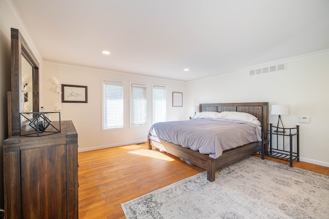 bedroom with baseboards, recessed lighting, wood finished floors, and visible vents