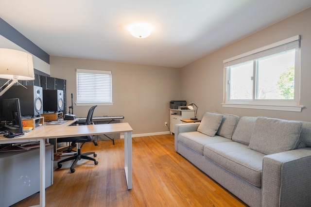 office space with baseboards and light wood-type flooring