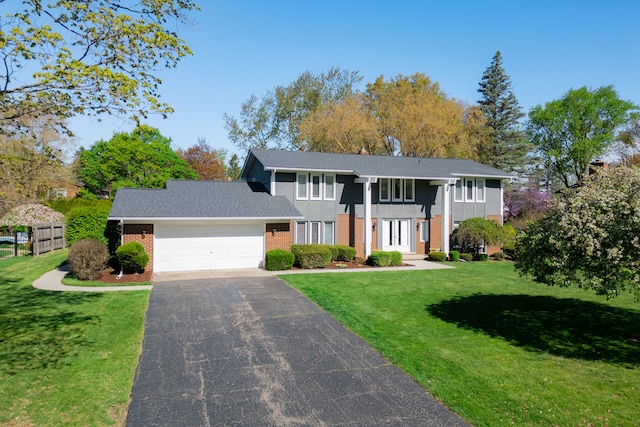 view of front facade featuring an attached garage, a front yard, brick siding, and aphalt driveway