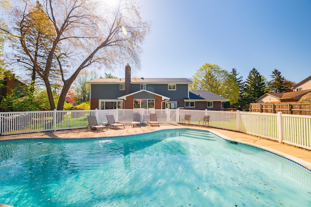 view of swimming pool featuring fence, a fenced in pool, and a patio