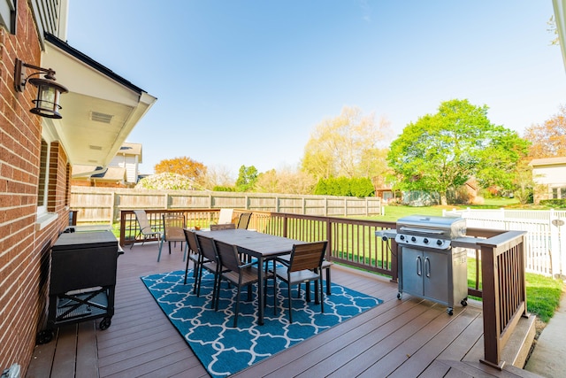 deck featuring outdoor dining space and a fenced backyard