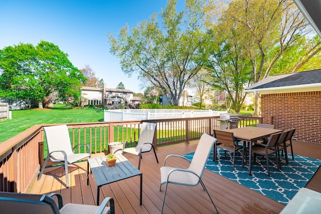 deck featuring fence, outdoor dining space, and a yard