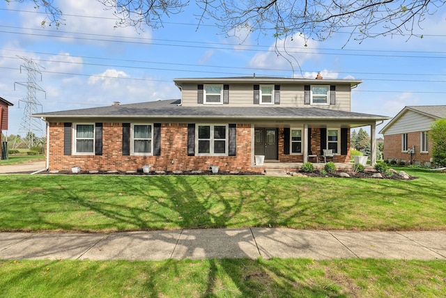 view of front of home featuring a porch, a front yard, and brick siding