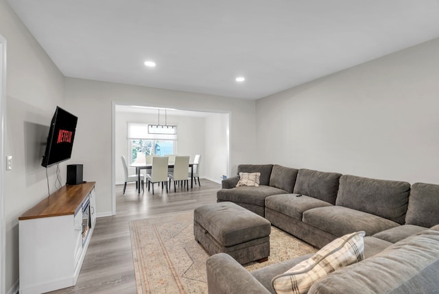 living area with recessed lighting, baseboards, and light wood-style flooring