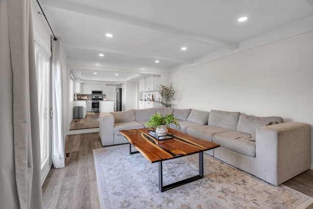 living area featuring recessed lighting, beam ceiling, and light wood-type flooring