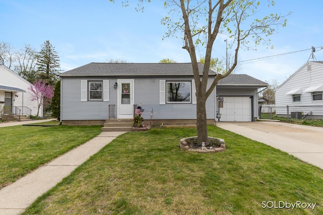 view of front of home featuring driveway, central AC unit, fence, a front lawn, and an attached garage