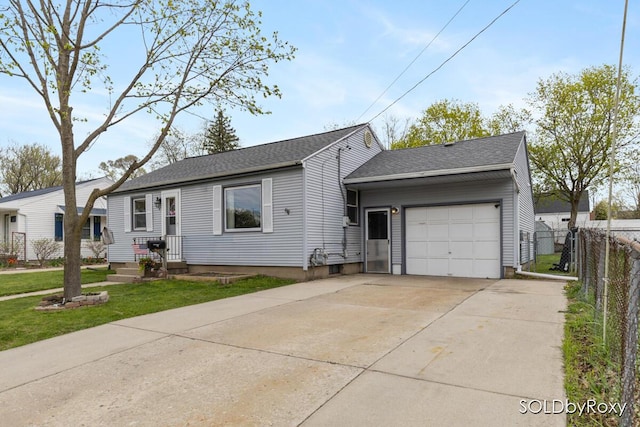 ranch-style house featuring a garage, fence, a front lawn, concrete driveway, and a shingled roof