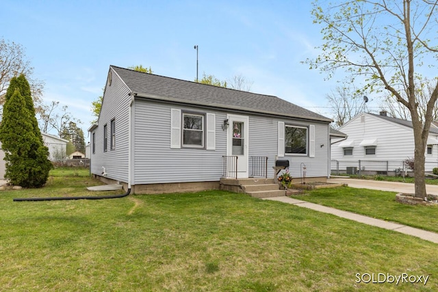 bungalow featuring fence, roof with shingles, and a front yard