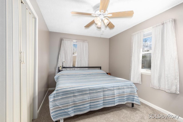 carpeted bedroom with baseboards and a ceiling fan