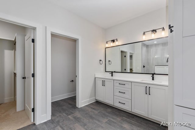 bathroom with a sink, baseboards, and double vanity