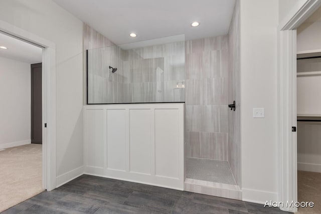 interior space with a walk in shower, baseboards, recessed lighting, and a walk in closet