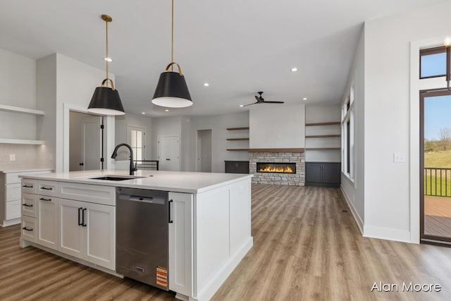 kitchen featuring ceiling fan, light wood-type flooring, white cabinetry, a sink, and dishwasher