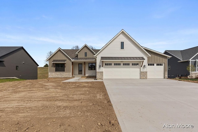 craftsman-style house featuring an attached garage, stone siding, board and batten siding, concrete driveway, and a standing seam roof