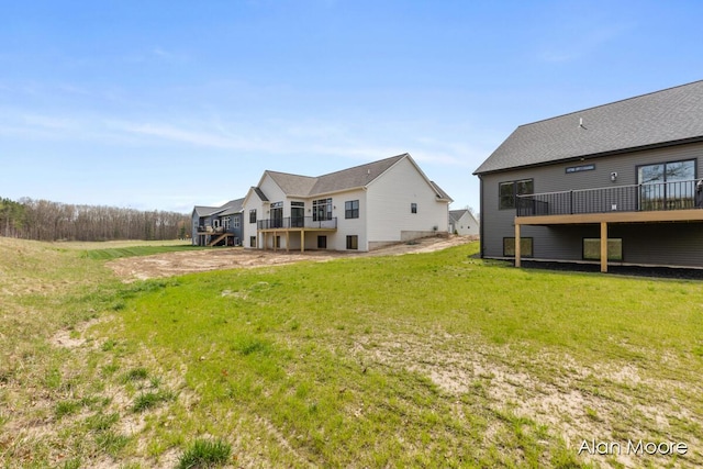 rear view of house with a lawn and a deck