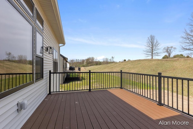 wooden terrace featuring a lawn