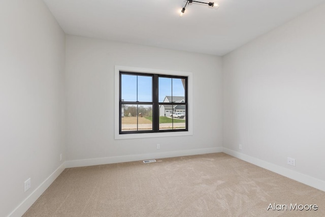 unfurnished room with baseboards, carpet, and visible vents