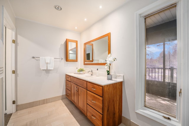 bathroom featuring vanity, baseboards, and recessed lighting