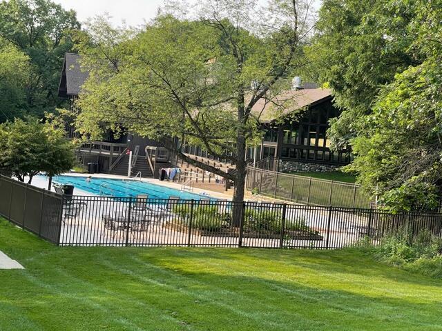 community pool featuring a yard and fence