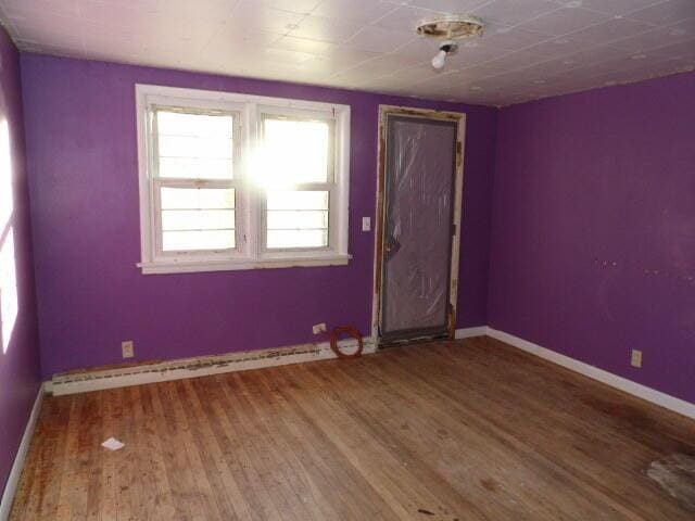unfurnished room featuring baseboards and wood finished floors