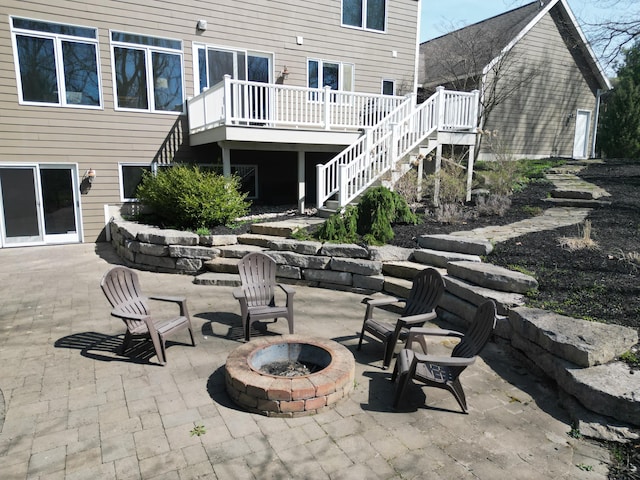 view of patio featuring a wooden deck, stairs, and an outdoor fire pit