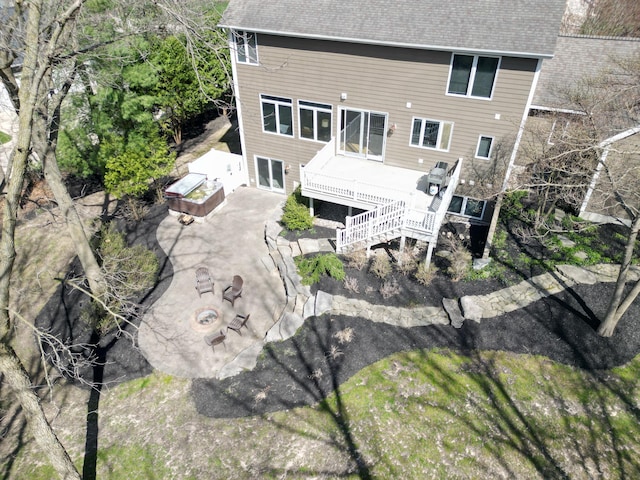 rear view of property with a fire pit, a deck, a patio, a shingled roof, and stairway