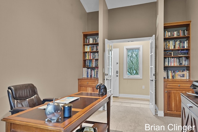 office space featuring baseboards, light tile patterned flooring, and light carpet