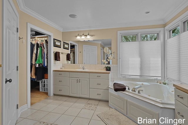 full bath featuring a walk in closet, vanity, tile patterned floors, a jetted tub, and ornamental molding
