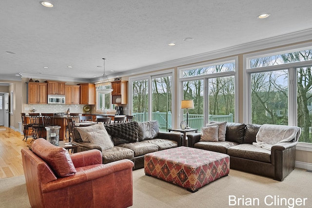 living area with recessed lighting, ornamental molding, light wood-style flooring, and baseboards