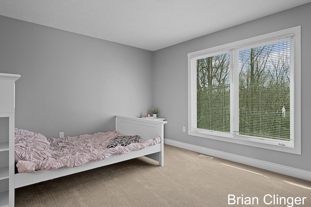 carpeted bedroom featuring baseboards and visible vents