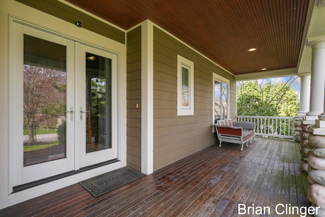 wooden terrace with a porch and french doors