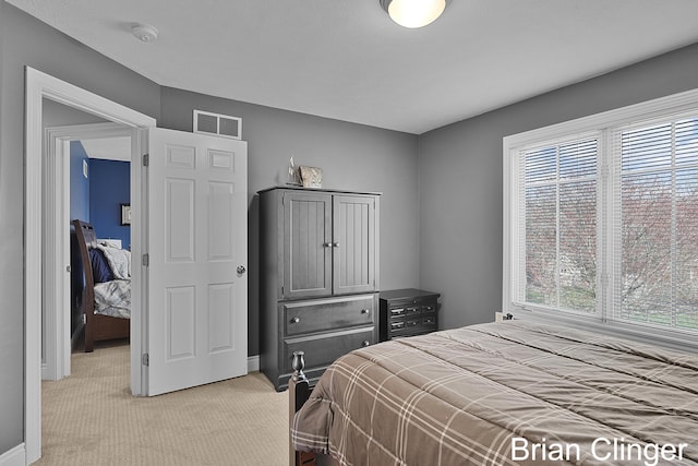 bedroom with baseboards, multiple windows, visible vents, and light colored carpet