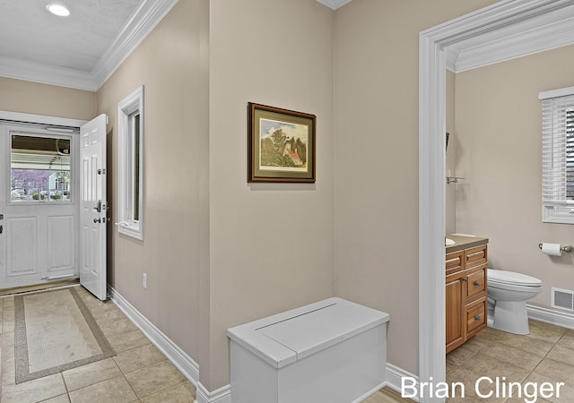 entrance foyer with baseboards, visible vents, ornamental molding, and light tile patterned floors