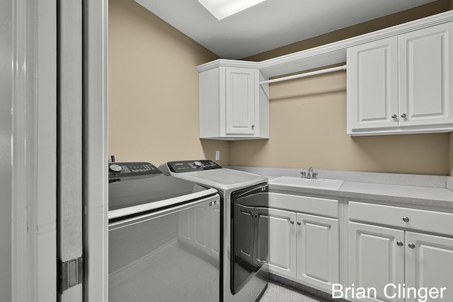 clothes washing area featuring a sink, cabinet space, and washing machine and clothes dryer