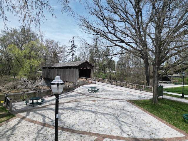 view of property's community featuring fence and an outbuilding