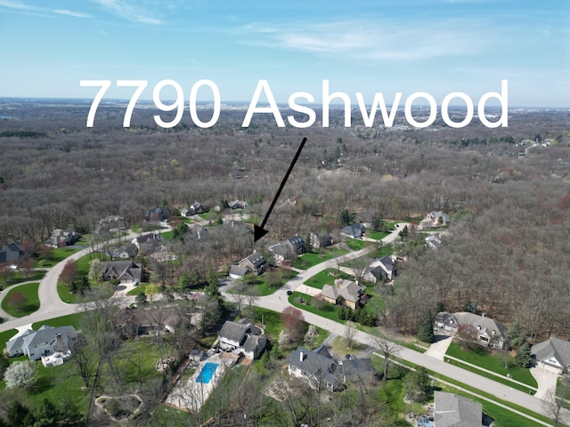 drone / aerial view featuring a view of trees and a residential view