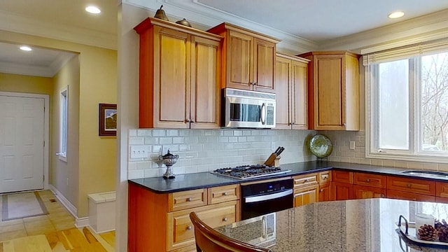 kitchen with plenty of natural light, crown molding, and stainless steel appliances