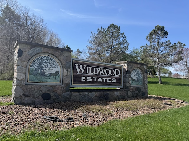 community / neighborhood sign with a yard
