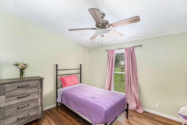 bedroom featuring a textured ceiling, baseboards, ceiling fan, and wood finished floors
