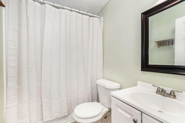 bathroom with toilet, a textured ceiling, curtained shower, and vanity