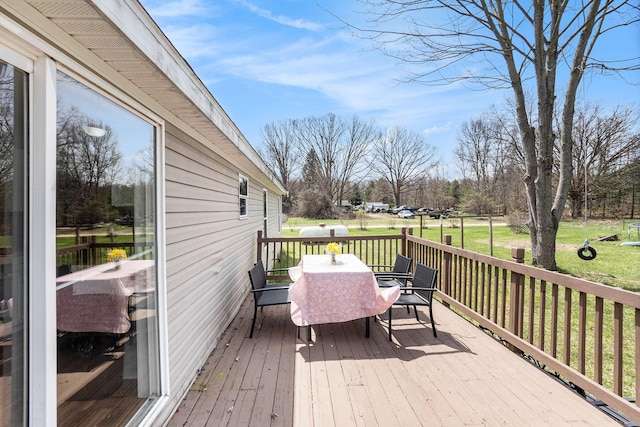 wooden deck with a lawn and outdoor dining space