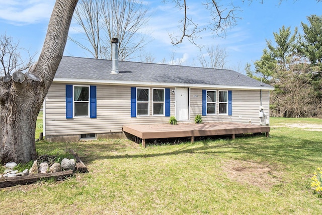 rear view of house with a lawn, a shingled roof, and a deck