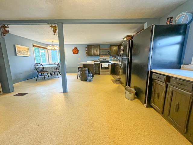 50002 M 51 N, Dowagiac, MI 49047 - kitchen featuring an inviting chandelier, light countertops, stainless steel appliances, and dark brown cabinets