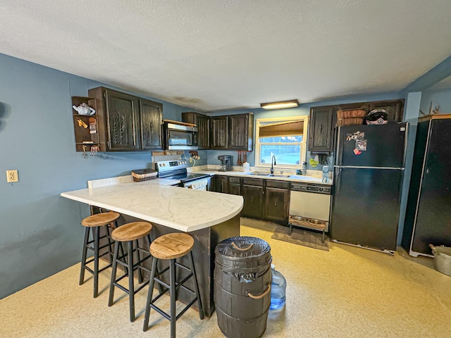 50002 M 51 N, Dowagiac, MI 49047 - kitchen with a kitchen bar, a sink, light countertops, a peninsula, and stainless steel appliances