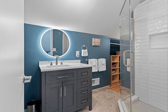 bathroom with vanity, a stall shower, and visible vents