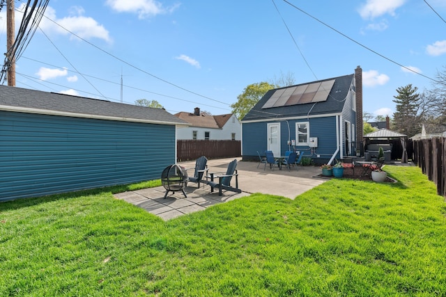 rear view of property with solar panels, a gazebo, a fenced backyard, a yard, and a patio