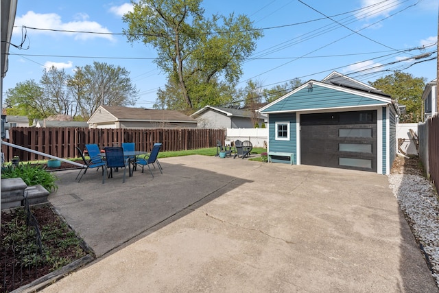 detached garage featuring fence and driveway