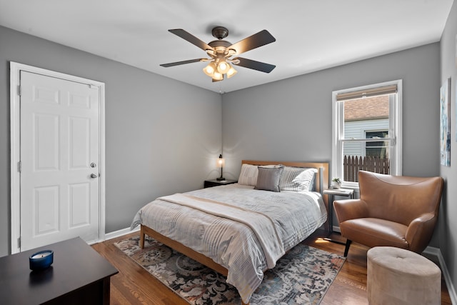 bedroom featuring baseboards, ceiling fan, and wood finished floors