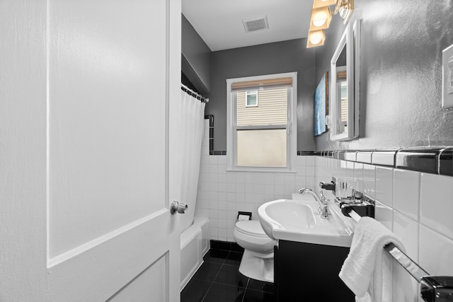 full bath featuring tile patterned flooring, visible vents, vanity, toilet, and tile walls