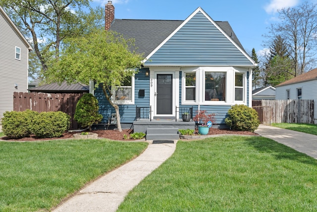 bungalow with a front lawn, roof with shingles, fence, and a chimney