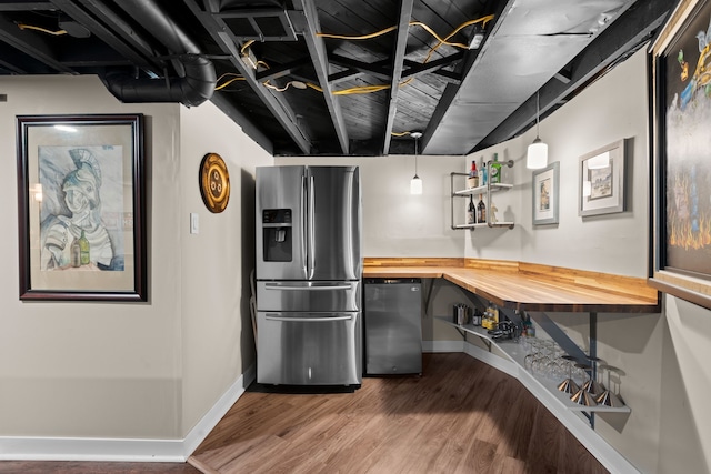 kitchen featuring wood finished floors, fridge, wooden counters, baseboards, and stainless steel fridge with ice dispenser